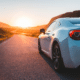 luxury car driving down mountain highway how to lower car insurance premium