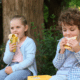 what to pack for kids lunchboxes young boy and girl eating a banana and a sandwich