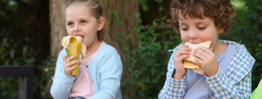 what to pack for kids lunchboxes young boy and girl eating a banana and a sandwich