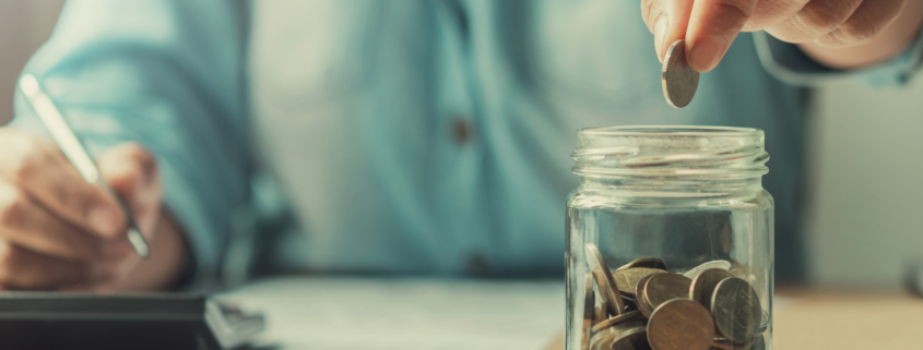 high yield savings account man dropping quarter into mason jar
