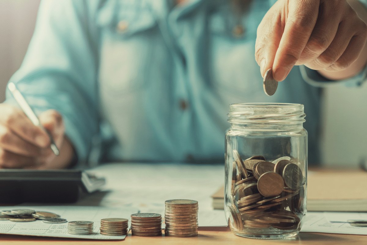 high yield savings account man dropping quarter into mason jar