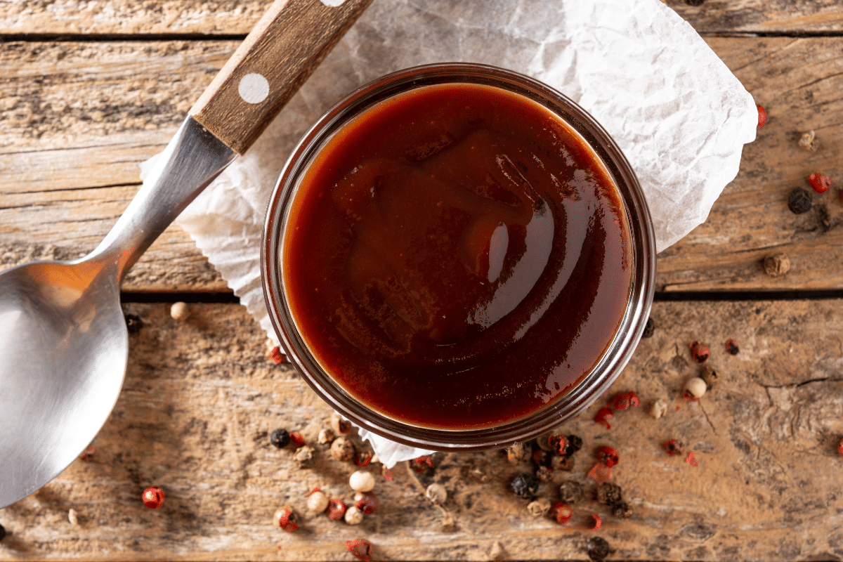 homemade bbq sauce recipe with peppercorn and a spoon