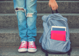 best inexpensive backpack girl holding bag with ripped jeans