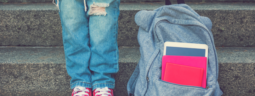 best inexpensive backpack girl holding bag with ripped jeans