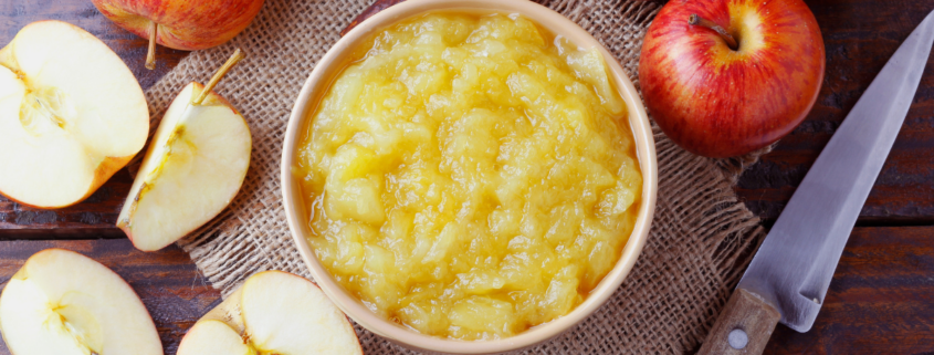 homemade applesauce recipe in a bowl with apples on countertop