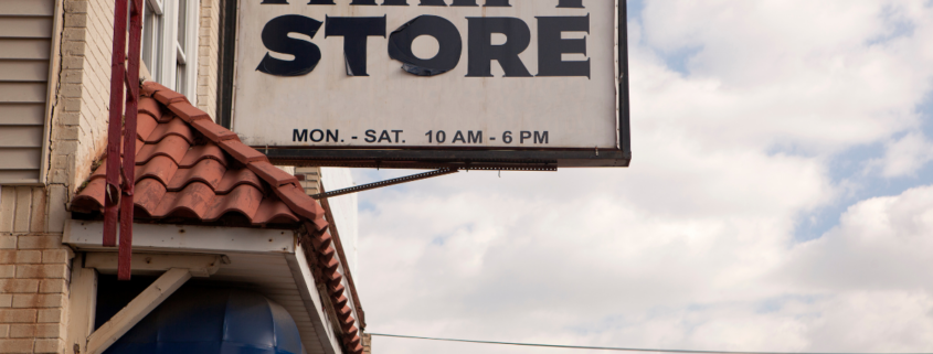 thrift store sign with blue cloudy sky in background