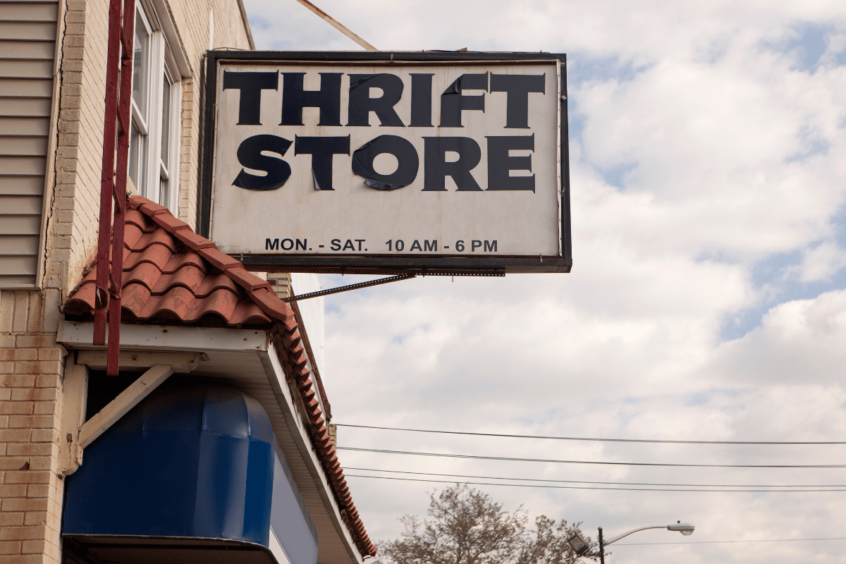 thrift store sign with blue cloudy sky in background