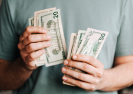 affluence more money isn't the answer man holding dollar bills