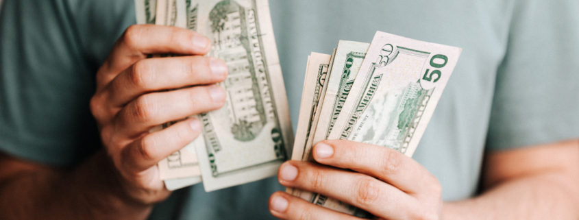 affluence more money isn't the answer man holding dollar bills
