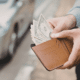 man pulling cash out of his wallet annualize your spending