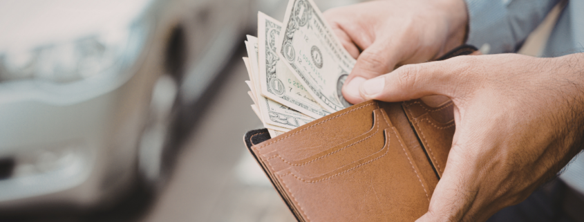 man pulling cash out of his wallet annualize your spending