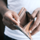 overspending habits man opening empty wallet
