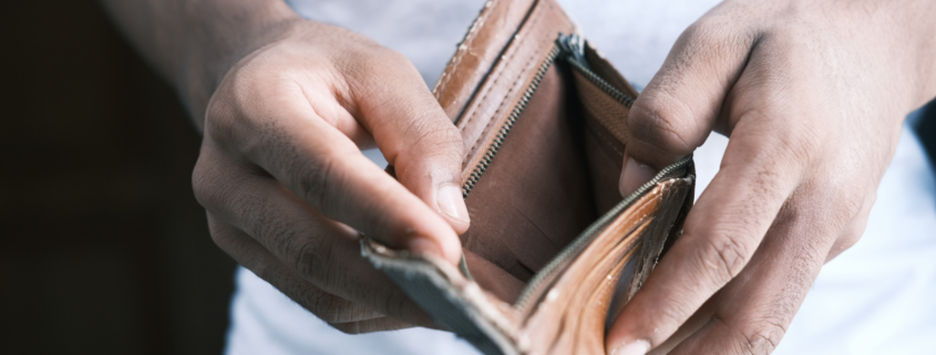 overspending habits man opening empty wallet