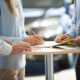 man and woman signing an extended warranty in a car dealership