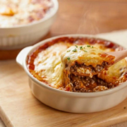 impossible lasagna pie recipe with wooden serving spoon in white casserole dish