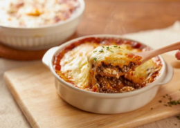 impossible lasagna pie recipe with wooden serving spoon in white casserole dish