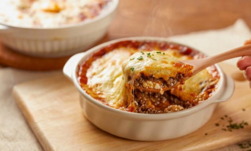 impossible lasagna pie recipe with wooden serving spoon in white casserole dish