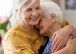 woman hugging elderly mother sandwich generation caring for aging parents