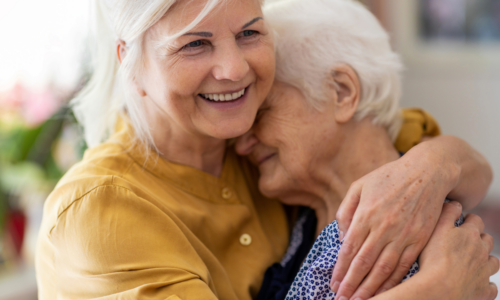 woman hugging elderly mother sandwich generation caring for aging parents