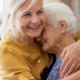 woman hugging elderly mother sandwich generation caring for aging parents