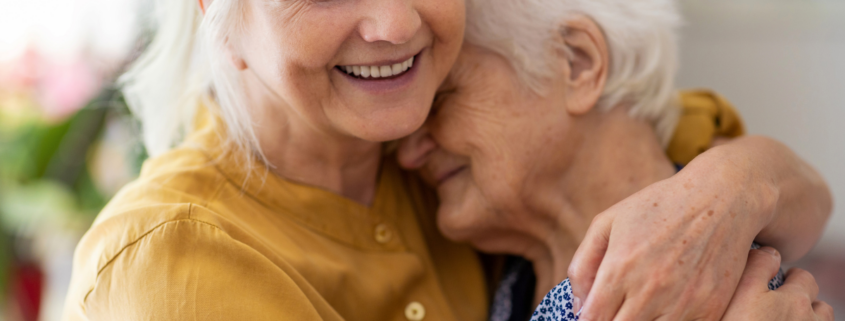 woman hugging elderly mother sandwich generation caring for aging parents