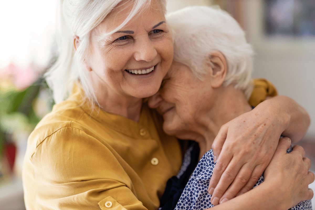 woman hugging elderly mother sandwich generation caring for aging parents