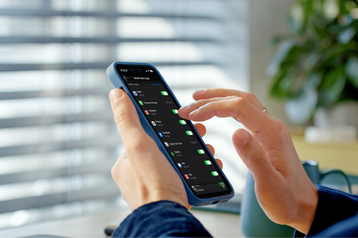 Woman looking at iPhone settings showing cellular data usage by app