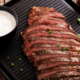 medium rare flank steak sliced against the grain with white horseradish sauce.