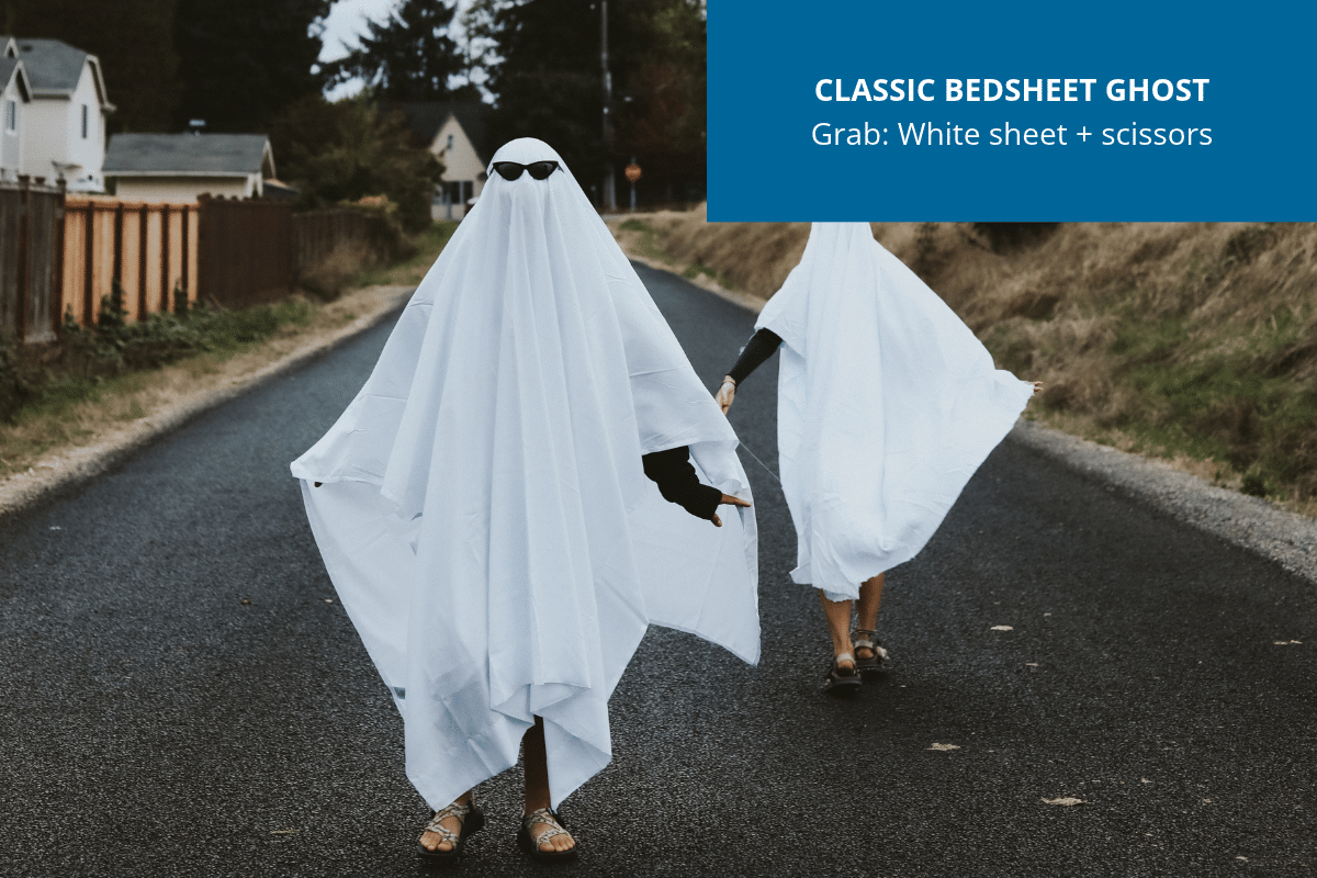 Person wearing a simple homemade Halloween ghost costume made from a white bedsheet