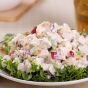 A close up of a bowl of salad, with Chicken and Teaspoon