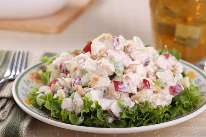A close up of a bowl of salad, with Chicken and Teaspoon