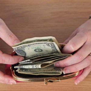 Woman putting money in her wallet