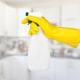 female hand in yellow rubber glove holding spray bottle of homemade cleaning solution