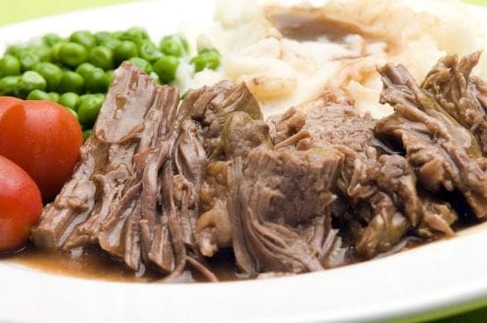 A plate full of food, with Gravy and Beef