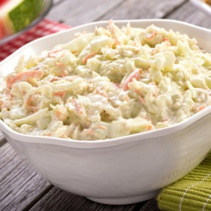 A bowl of rice on a plate, with Coleslaw