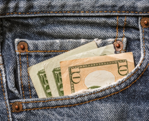 USD currency in jeans pocket