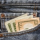USD currency in jeans pocket
