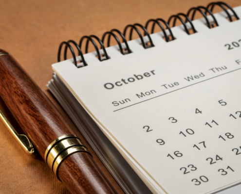October 2022 - closeup of a small desktop calendar with a pen, time and business concept