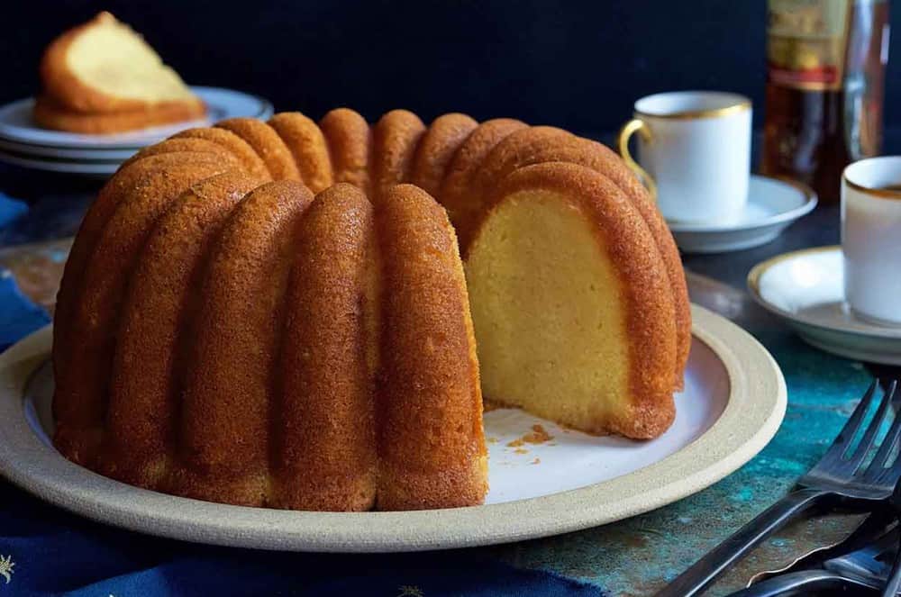 A close up of a plate of food and a cup of coffee, with Bundt cake