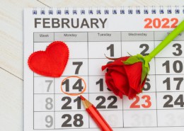 On the 2022 calendar, the date 14 February is marked in red pencil - Valentine's Day. Flat lay