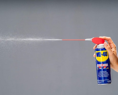 person spraying WD-40