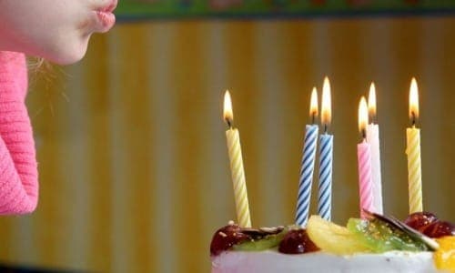 A plate of food with a birthday cake, with Candle
