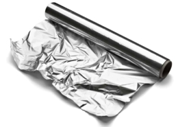 a roll of aluminum foil on white background slightly unrolled and crinkled