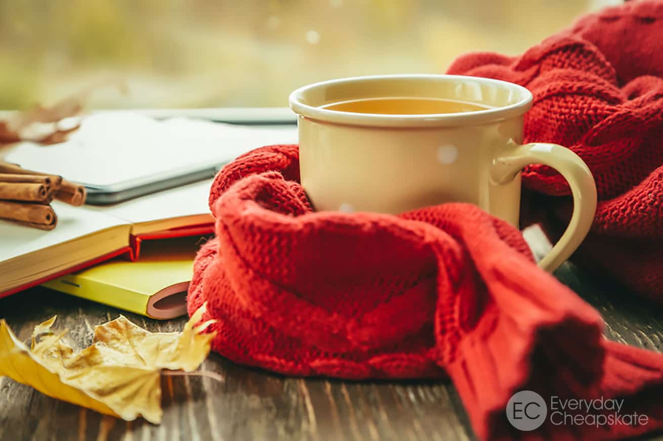 Autumn tea with scarf and leaves in front of window
