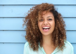 Portrait of a cheerful young woman with bea utiful white-teeth smile