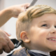 Blond little boy having a haircut at hair salon