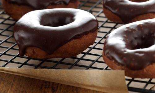 potato doughnuts with chocolate glaze cooling on a rack