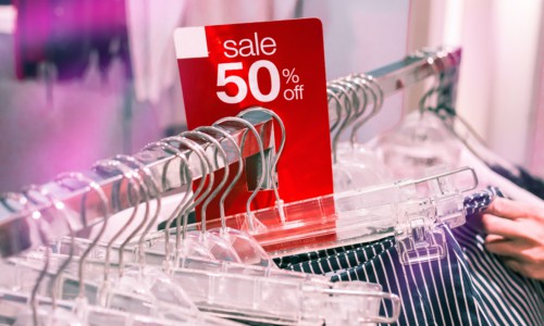 clothes shopping in clothing store 50 percent off sale rack