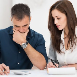 Portrait Of A Worried Couple Calculating Financial Budget