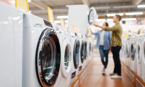 Couple choosing washing machine, electronics store